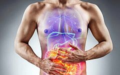 Man holding his stomach in pain. Photo of man with naked torso experience irritable bowel syndrome on grey background. Medical concept