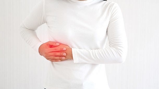 hepatitis and hepatomegaly, including cholangio carcinoma in woman and she touching in the upper right portion of abdomen and above stomach symptoms of pain and suffering use for health care concept.